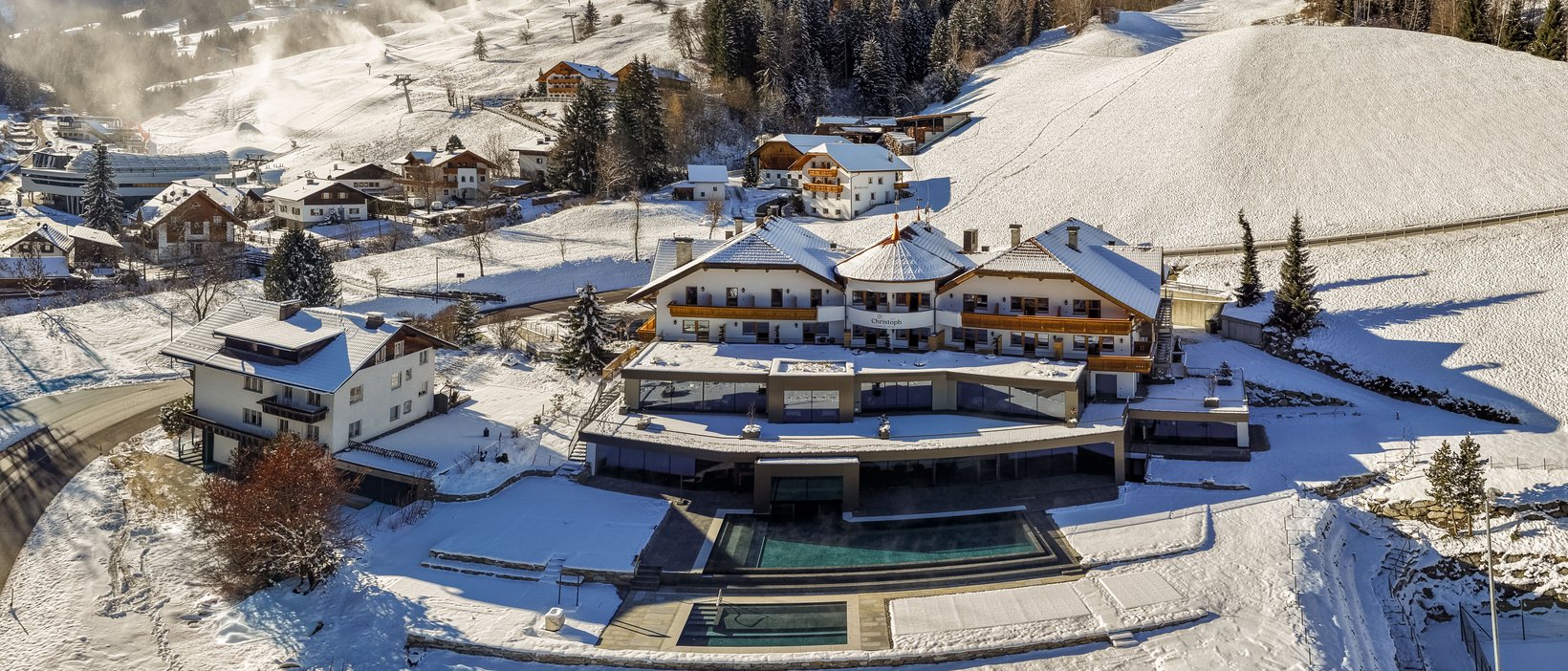 Unvergesslicher Skiurlaub am Kronplatz Hotel in verschneiter Berglandschaft mit Skigebiet und Wald