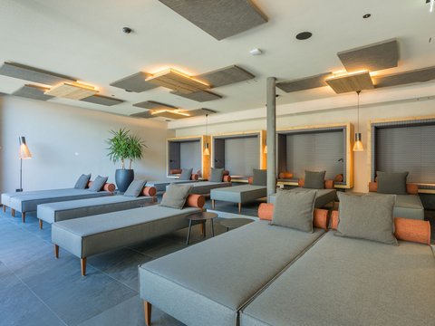 The four buildings of our accommodation in Val Pusteria/Pustertal Modern cozy relaxation room with loungers and soft lighting