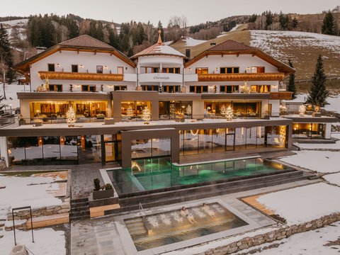 Family hotel a Valdaora: la famiglia Lanz Hotel con alberi di Natale illuminati e piscina esterna in paesaggio montano innevato