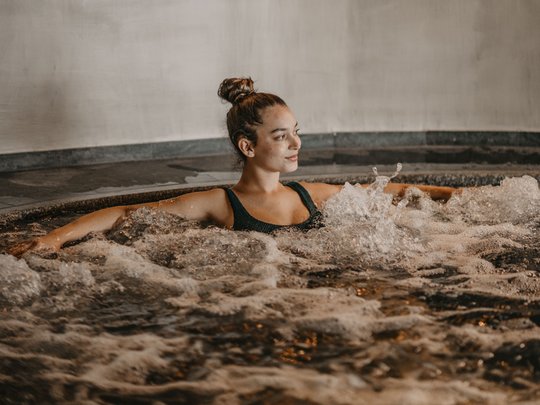 Una giornata di relax Donna rilassata in una vasca idromassaggio con acqua frizzante