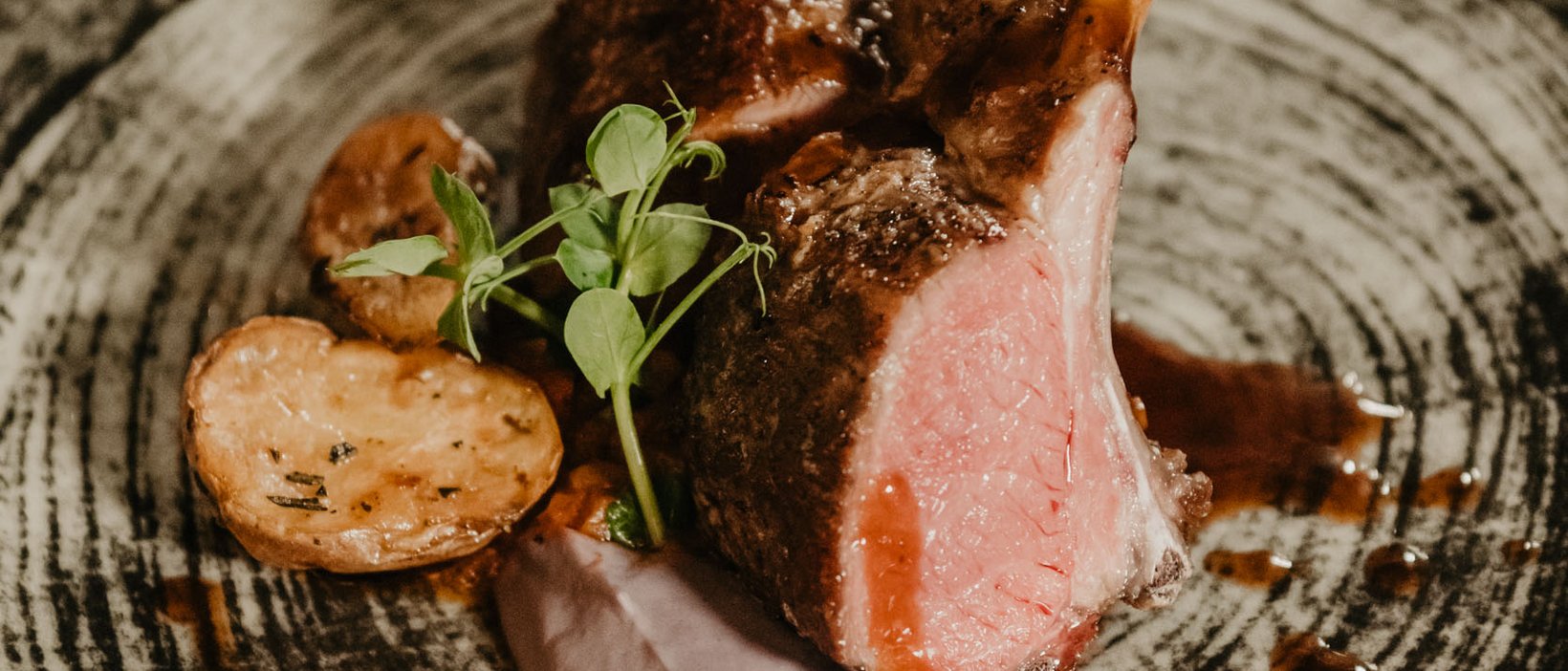 In the best hands: massages at Hotel Christoph Lamb chops with sauce, potatoes, and greens on a rustic plate