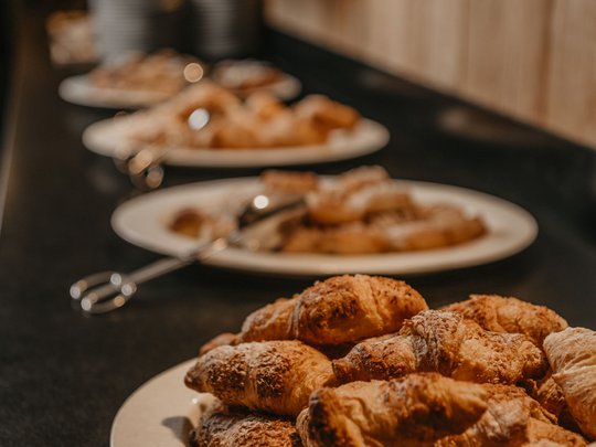 Concedetevi una pausa Cornetti freschi su un piatto bianco in fila al buffet