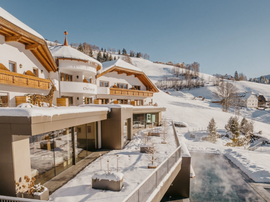 Hotel in Val Pusteria con piscina Hotel innevato con piscina all'aperto e montagne sullo sfondo