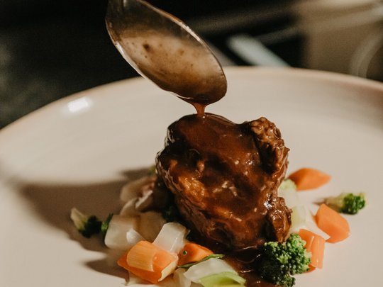 Concedetevi una pausa Piatto di carne con salsa e verdure servito su piatto bianco