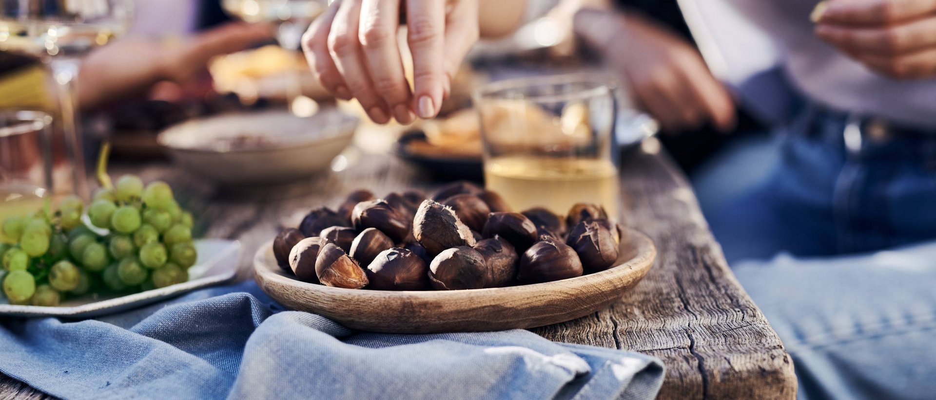 Il sapore dell’autunno pusterese Una mano dispone piccoli dolci scuri su un piatto
