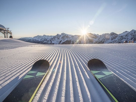 Unforgettable skiing holiday on Plan de Corones/Kronplatz View of freshly groomed ski slope at sunrise in the mountains