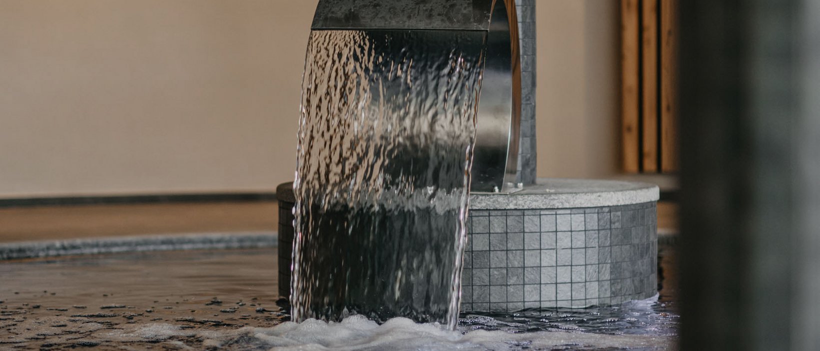 Unforgettable skiing holiday on Plan de Corones/Kronplatz Water flows from a metal pipe into a heated indoor pool