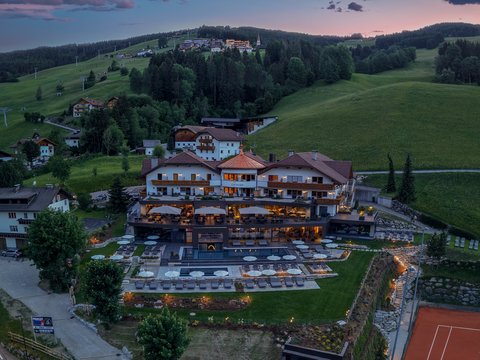 Around our hotel on the piste in Plan de Corones/Kronplatz Hotel Christoph with pool and terrace in green hilly landscape at dusk