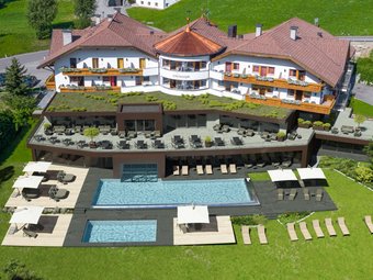 Hotel al Plan de Corones con spa: vacanza à la Christoph Hotel con piscina esterna e lettini su prato verde