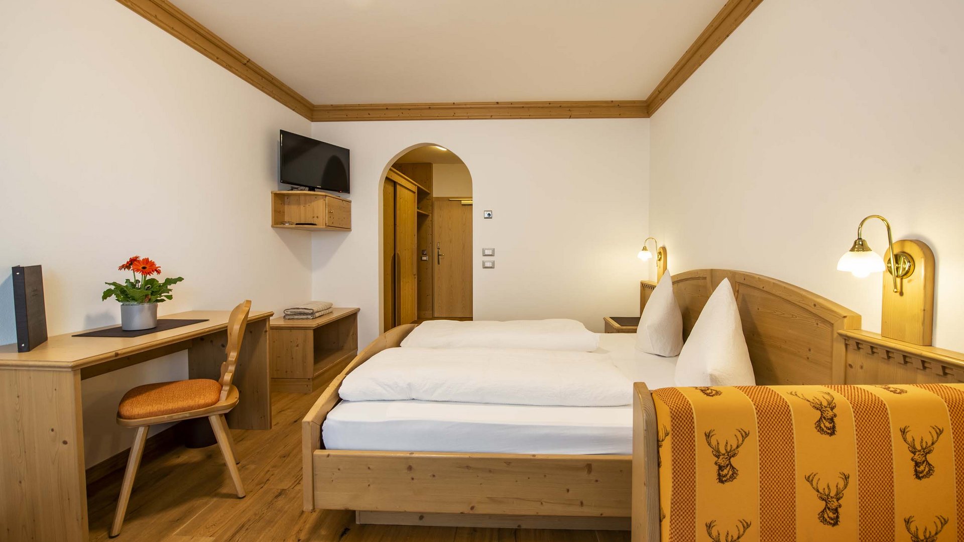 Willkommen in Olang: Hotel Christoph Gemütliches Hotelzimmer mit Holzmöbeln und Doppelbett