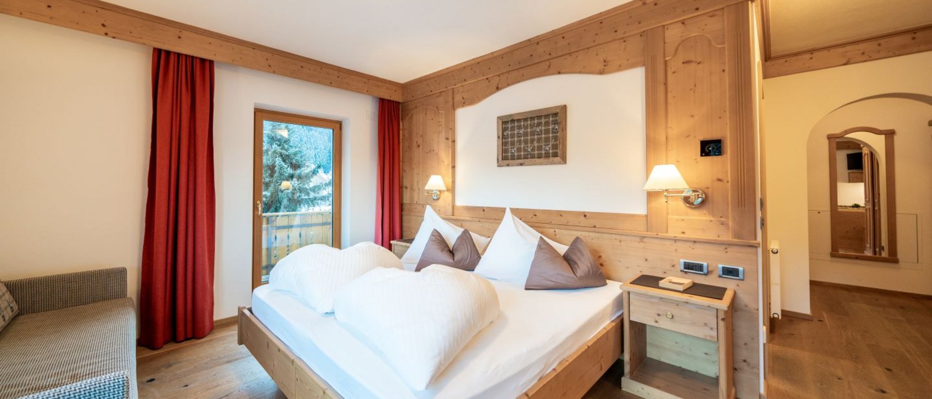 Sentirsi a casa all’Hotel Christoph Camera d'albergo accogliente con mobili in legno e letto matrimoniale