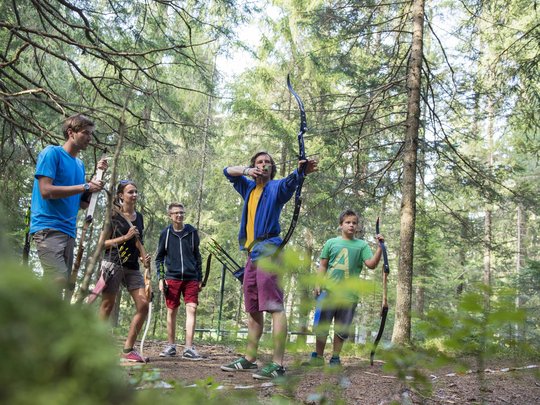 Hotel + Plan de Corones + Olang = mountain biking, climbing, tennis Group of five people practicing archery in a forest