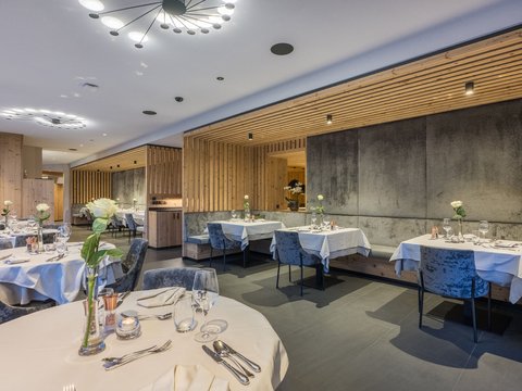 Hotel + Kronplatz + Olang = Mountainbiken, Klettern, Tennis Elegantes Restaurant mit weißen Tischtüchern, Blumen und moderner Beleuchtung