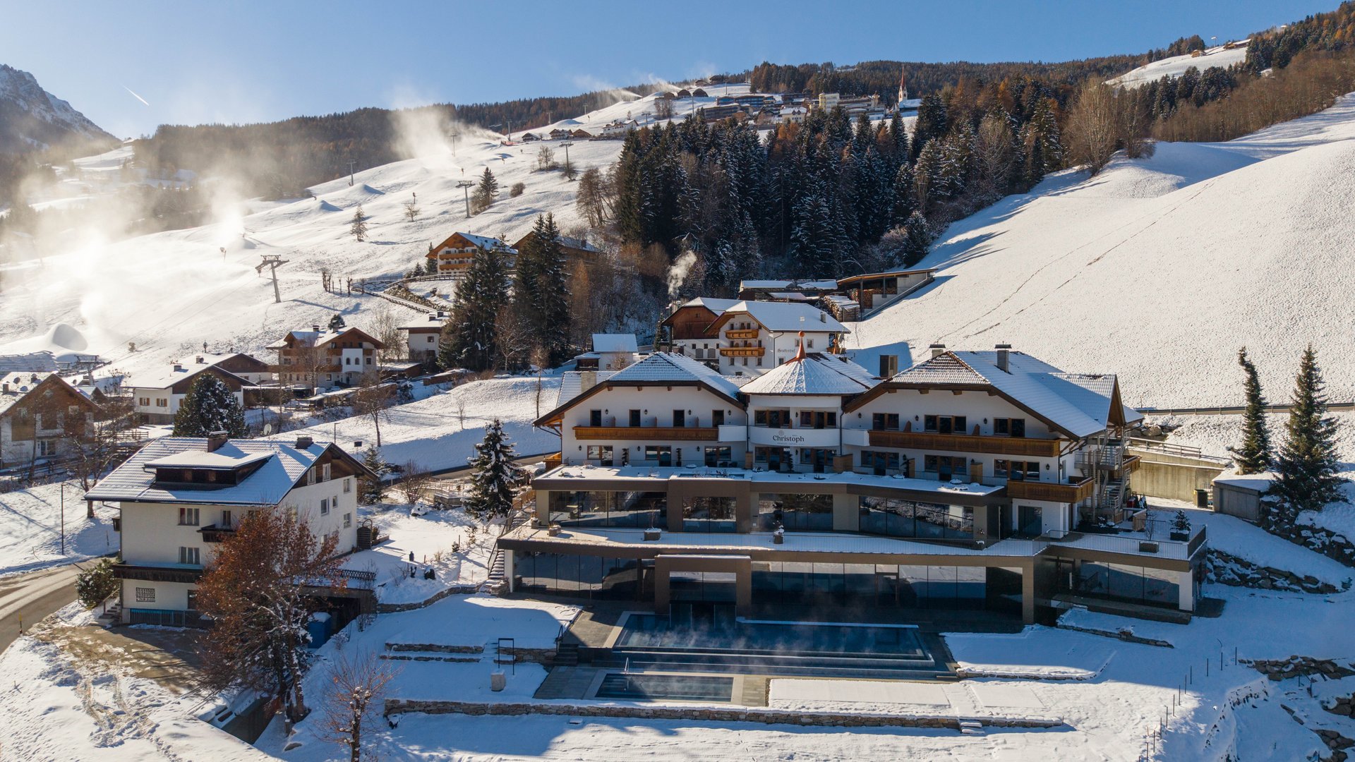 Valdaora: Hotel Christoph Resort innevato e area sciistica in montagna in una giornata soleggiata d'inverno