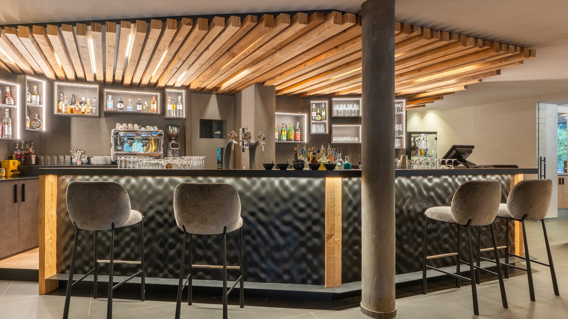 Welcome to Hotel Christoph in Olang, Plan de Corones/Kronplatz Modern hotel bar area with illuminated wood design and tall bar stools