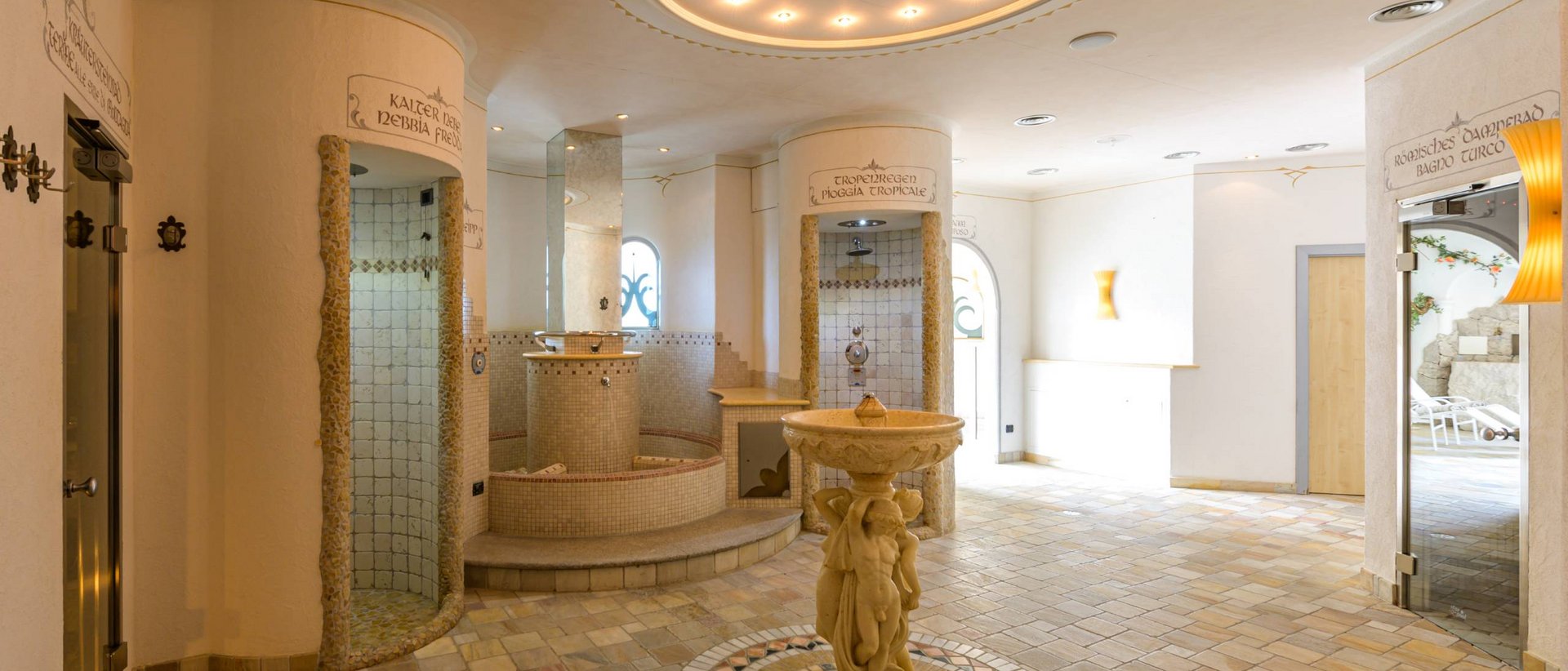 Entspannung in der hoteleigenen Sauna Heller Spa-Bereich mit runder Statue und Duschkabinen