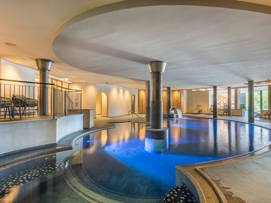 In the best hands: massages at Hotel Christoph Modern indoor pool with illuminated water and lounge chairs