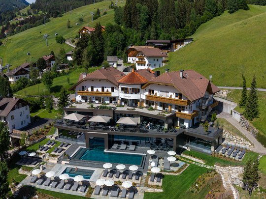 A swim in Lago di Braies? A hotel with a pool? Let’s go for a dip! Hotel with pool and umbrellas in the mountains under clear sky