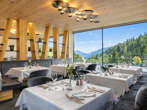Le novità del nostro hotel a 4 stelle tra le Dolomiti Ristorante elegante con accenti in legno e vista sulle montagne da grandi finestre
