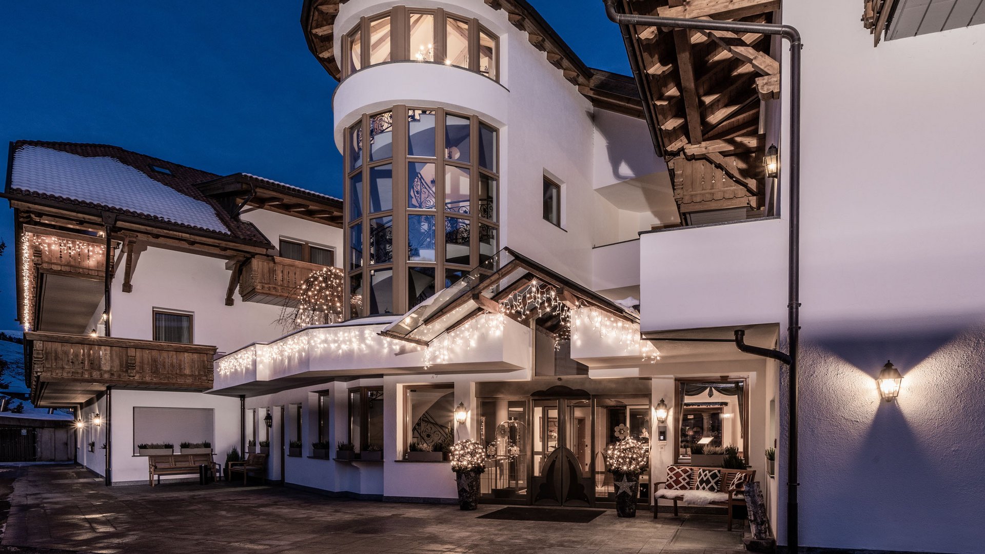 Hotel 4 stelle in Val Pusteria: sostenibile per natura Ingresso illuminato di una casa alpina moderna al crepuscolo