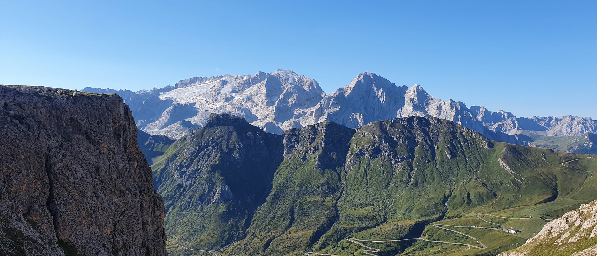 Aktivurlaub im Pustertal Berglandschaft mit schneebedeckten Gipfeln und kurviger Straße bei klarem Himmel