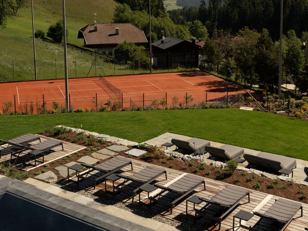 Fitness nel nostro hotel di lusso sulle Dolomiti Campo da tennis e lettini con vista sulle montagne innevate