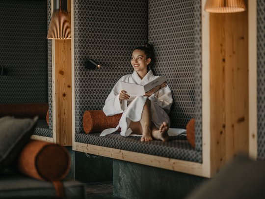 Una giornata di relax Donna in accappatoio che legge rilassata in un'area lounge moderna