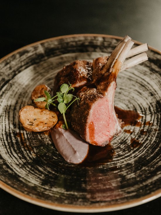 Hotel al Plan de Corones con spa: vacanza à la Christoph Costolette di agnello grigliate con patate e salsa su un piatto decorativo