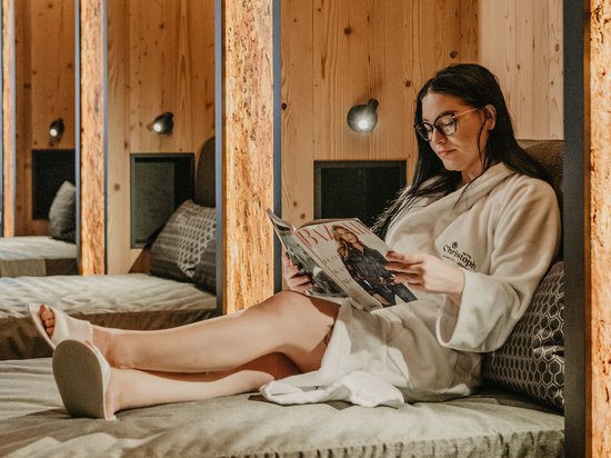 Concedetevi una pausa Donna in accappatoio legge una rivista su una chaise longue in una sala relax moderna