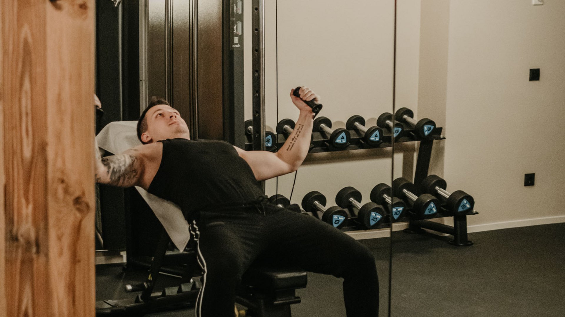 Fitness near Lago di Braies/Pragser Wildsee: stay at Hotel Christoph Man exercising with cable machine in gym in front of mirror
