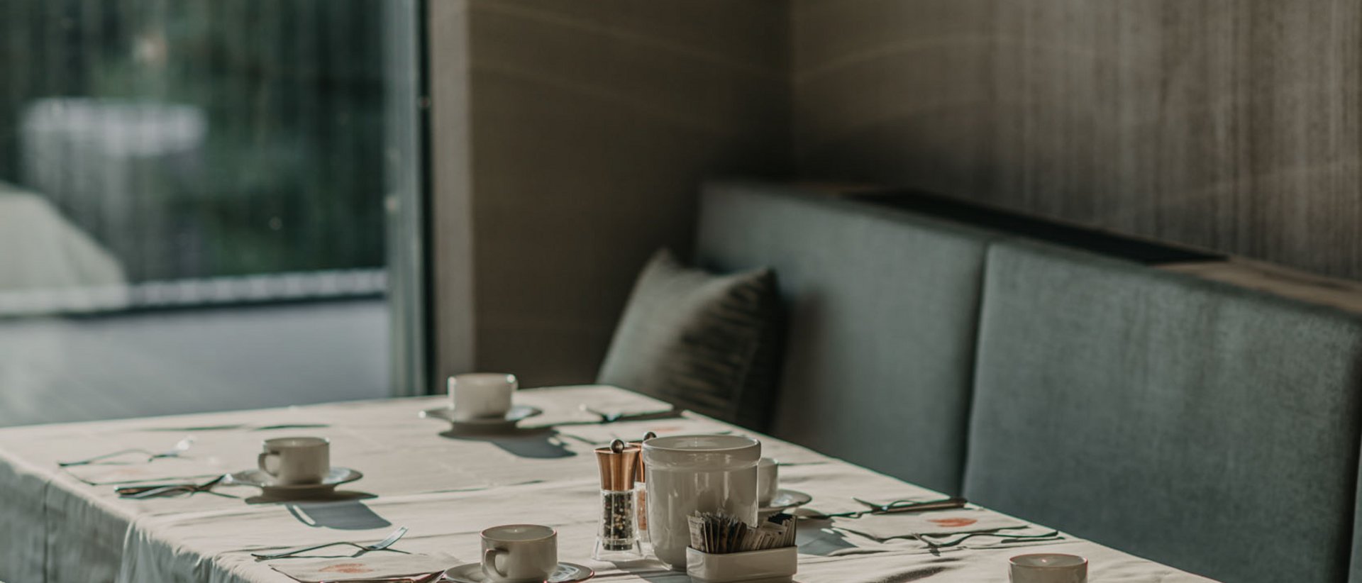 Ricetta natalizia Tavolo apparecchiato con tovaglia bianca e lampade a sospensione moderne