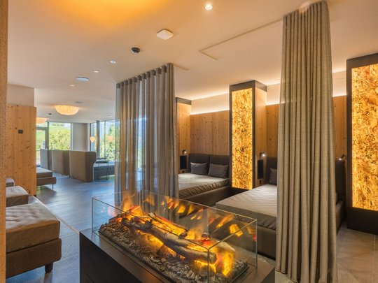 Le novità del nostro hotel a 4 stelle tra le Dolomiti Lounge moderna con camino, pareti in legno e aree salotto accoglienti con tende