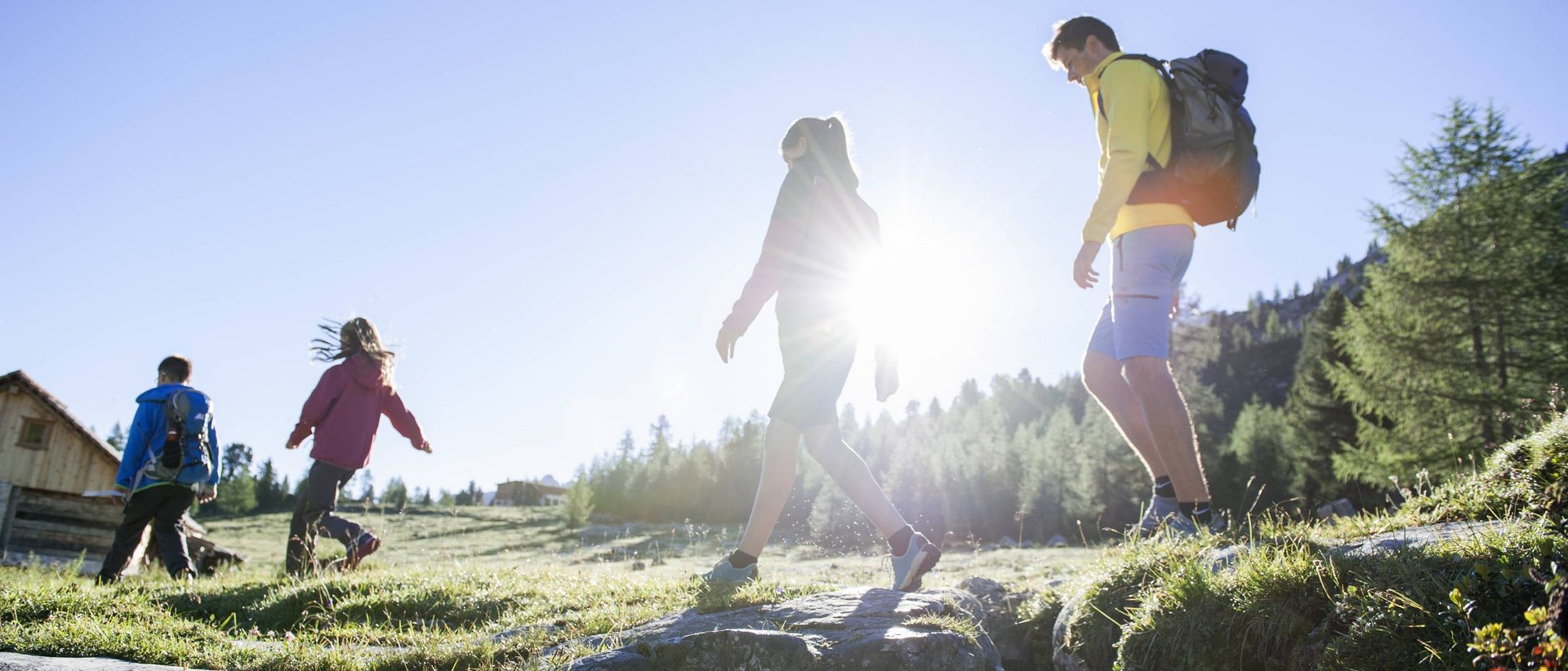 Facile escursione a Prato Piazza Gruppo di persone che cammina su un prato di montagna al sole