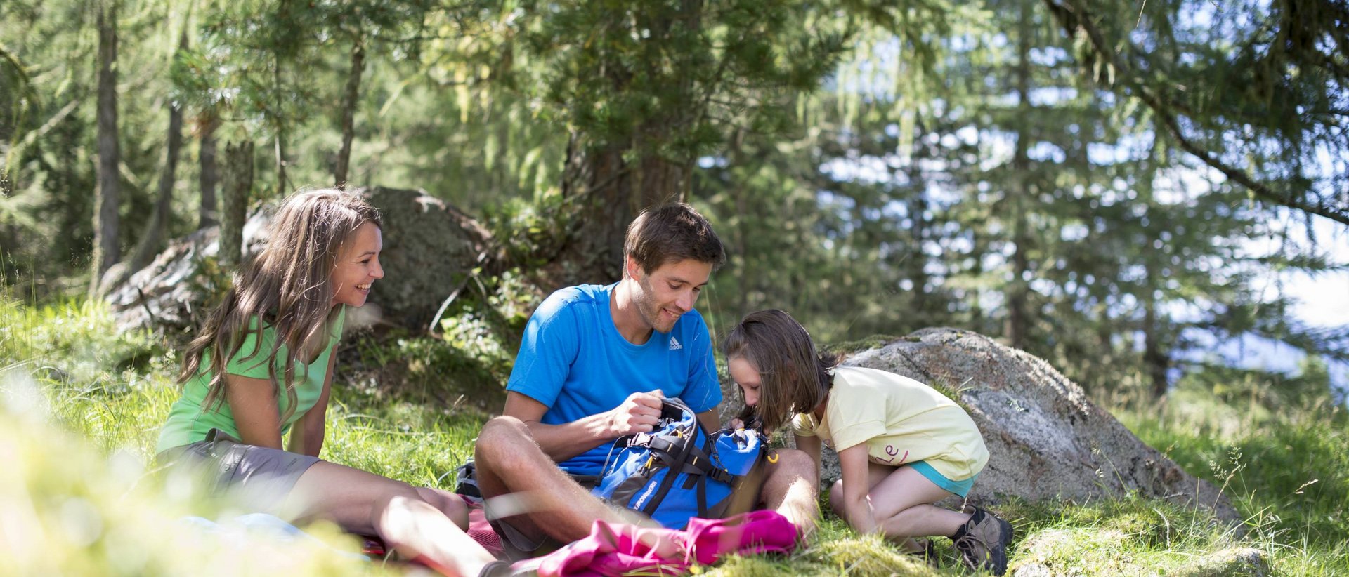 Familienurlaub im Hotel Christoph Familie macht Pause beim Wandern im Wald auf einer Graslichtung