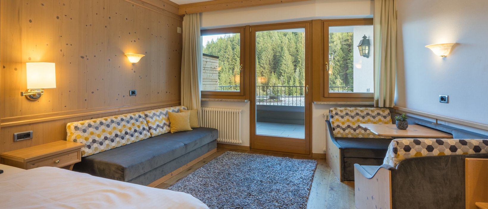 Hotel Olang: Willkommen, liebe Gäste und Freunde! Gemütliches Hotelzimmer mit Balkon und Waldblick