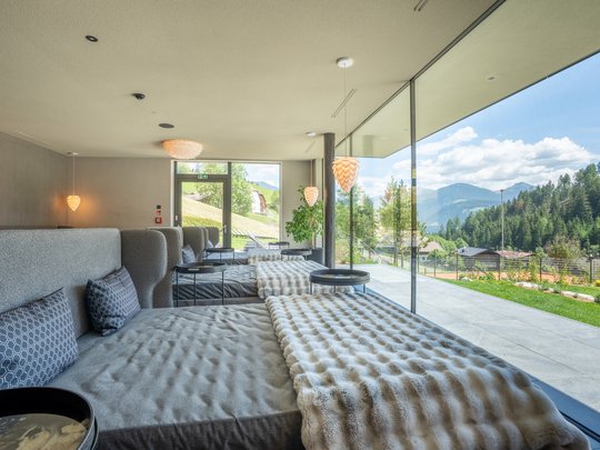 Le novità del nostro hotel a 4 stelle tra le Dolomiti Sala relax moderna con grandi finestre e vista sulle montagne