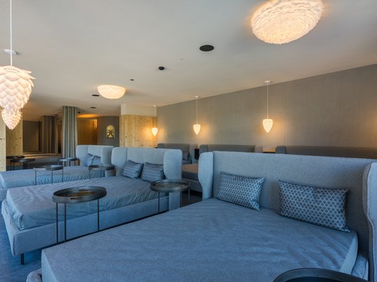 Day Spa Moderne Lounge mit grauen Sofas und dekorativen Hängelampen an der Decke